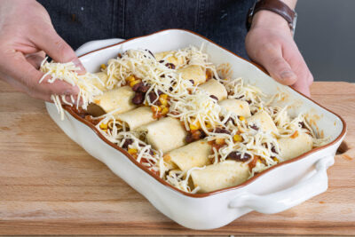 Enchiladas mit Hackfleisch mit Sauce und Käse beträufeln
