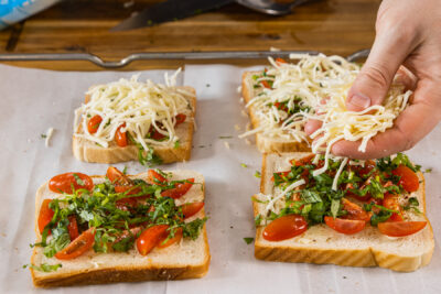 Geriebenen Mozzarella über die Toast geben