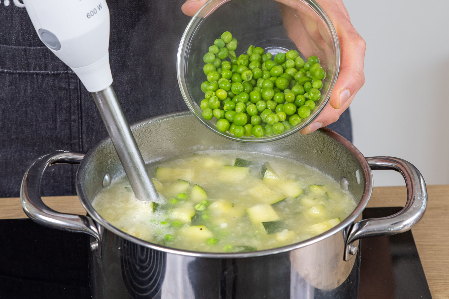 Erbsen zur Zucchinisuppe geben und pürieren