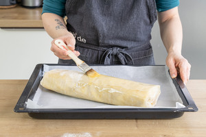 Apfelstrudel mit Butter bestreichen