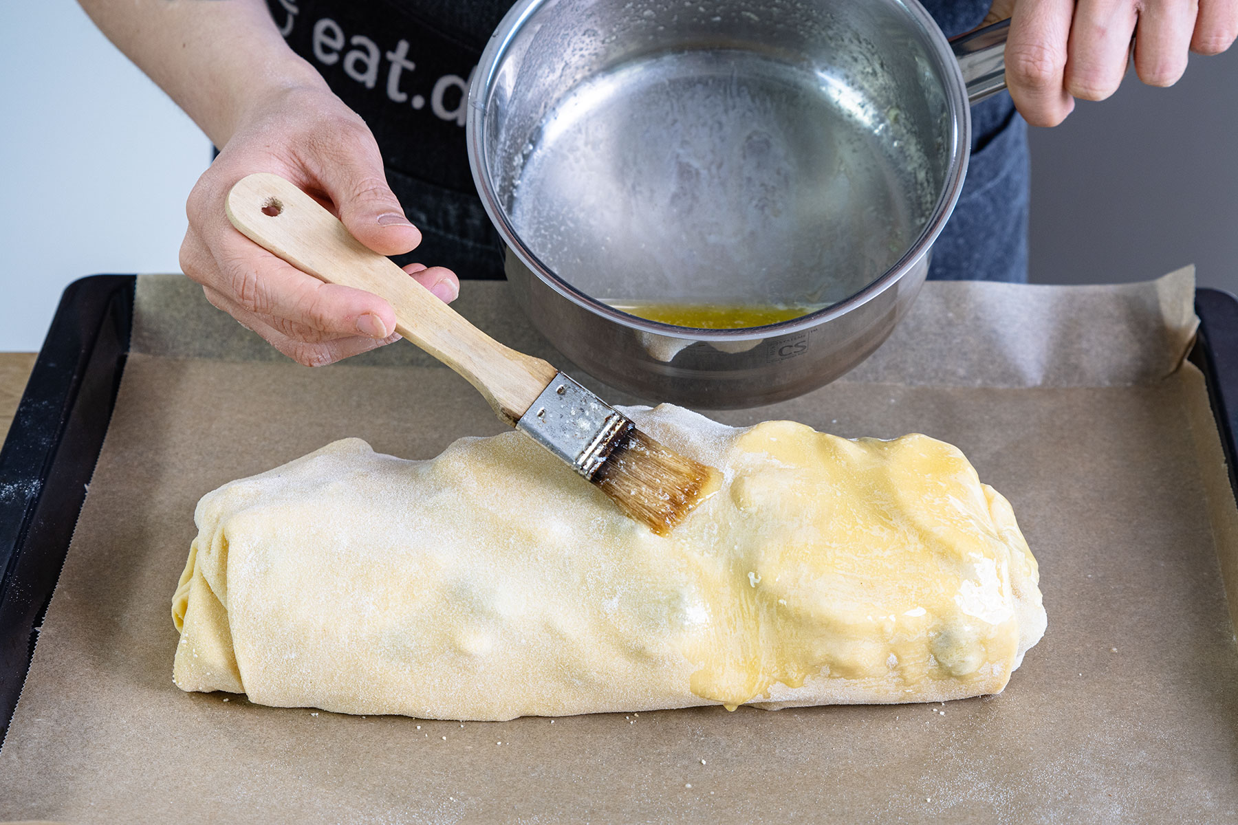 Apfelstrudel mit Butter bestreichen