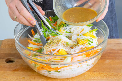 Nudelsalat mit dem Dressing vermengen