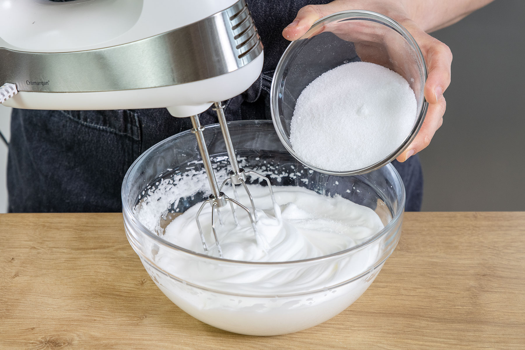 Zucker und Vanillezucker zum Eischnee geben