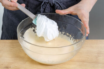 Eischnee zu dem aufgeschlagenen Eigelb geben
