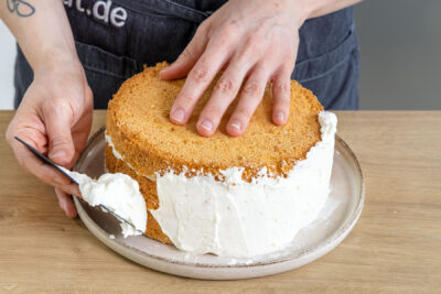 Fruchtige Mango-Maracuja-Torte mit der Creme einstreichen