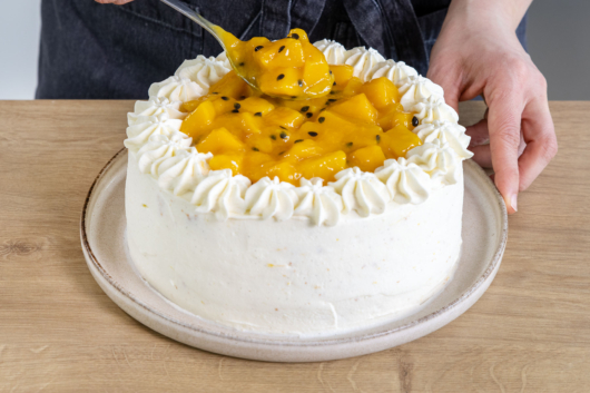 Mangokompott auf die fruchtige Mango-Maracuja-Torte geben
