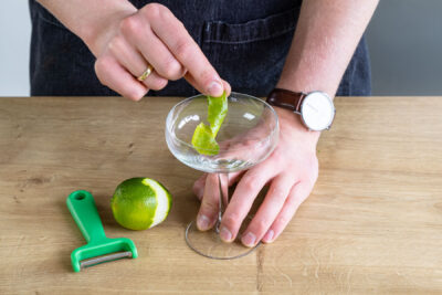 Limettenschale an Glasrand reiben