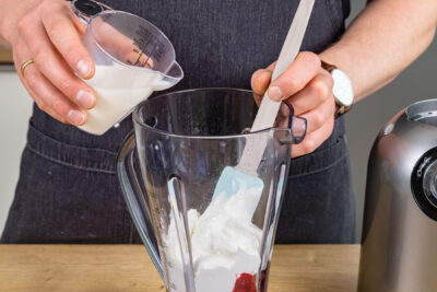 Milch in Standmixer gießen