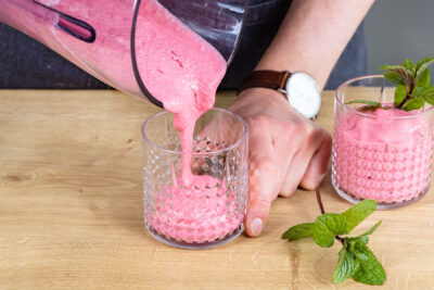Himbeer-Smoothie in Glas füllen