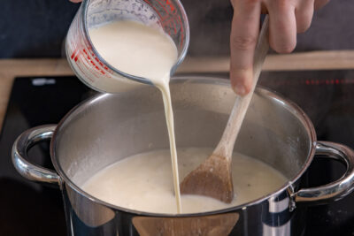 Sahne zur Knoblauchsuppe gießen