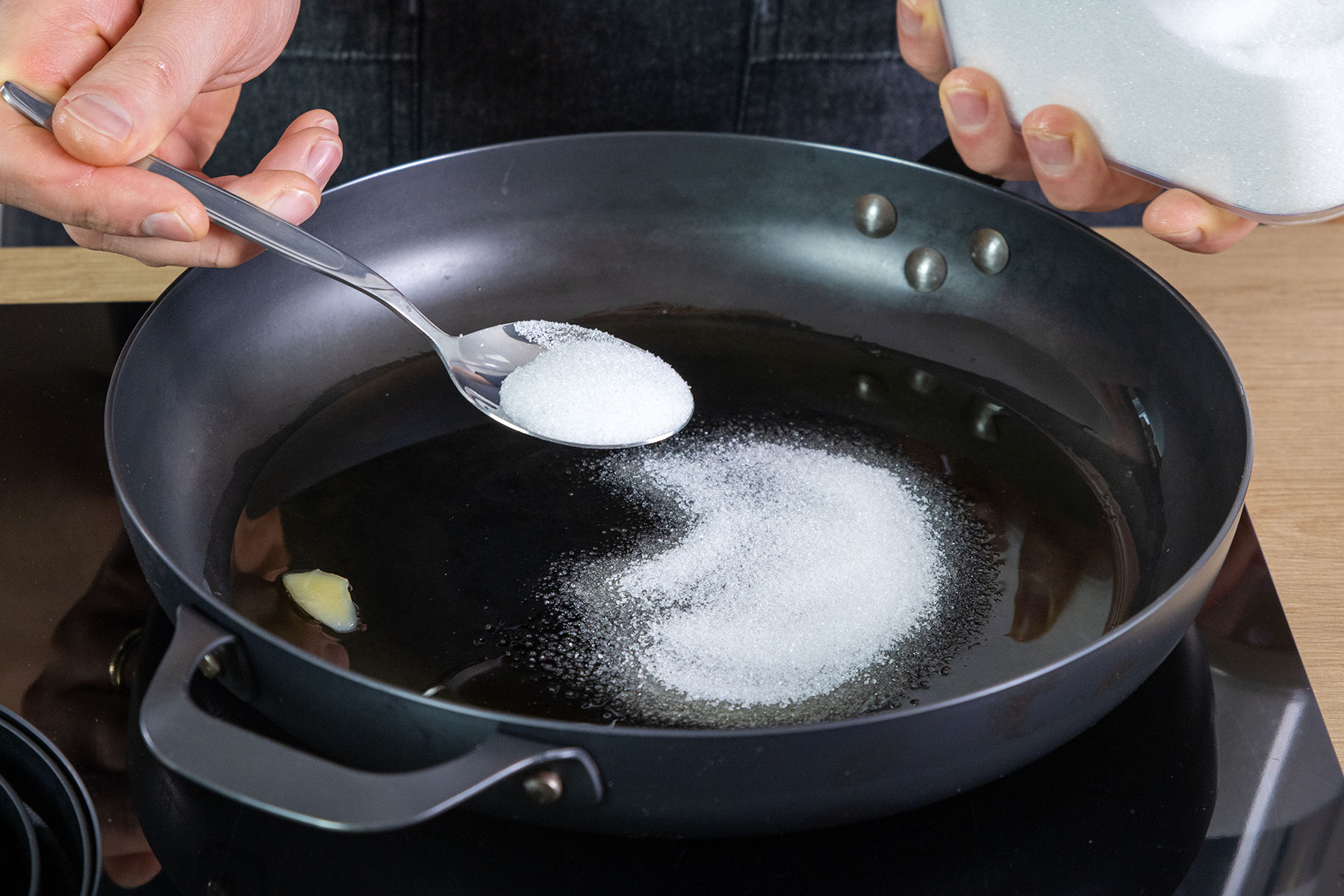 Zucker zu dem zerlassenen Butterschmalz in die Pfanne geben