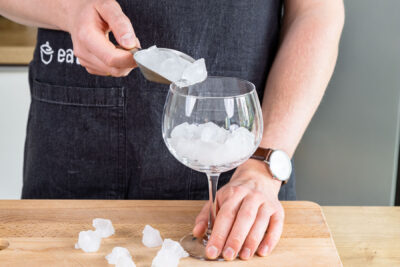 Eiswürfel in ein Glas füllen