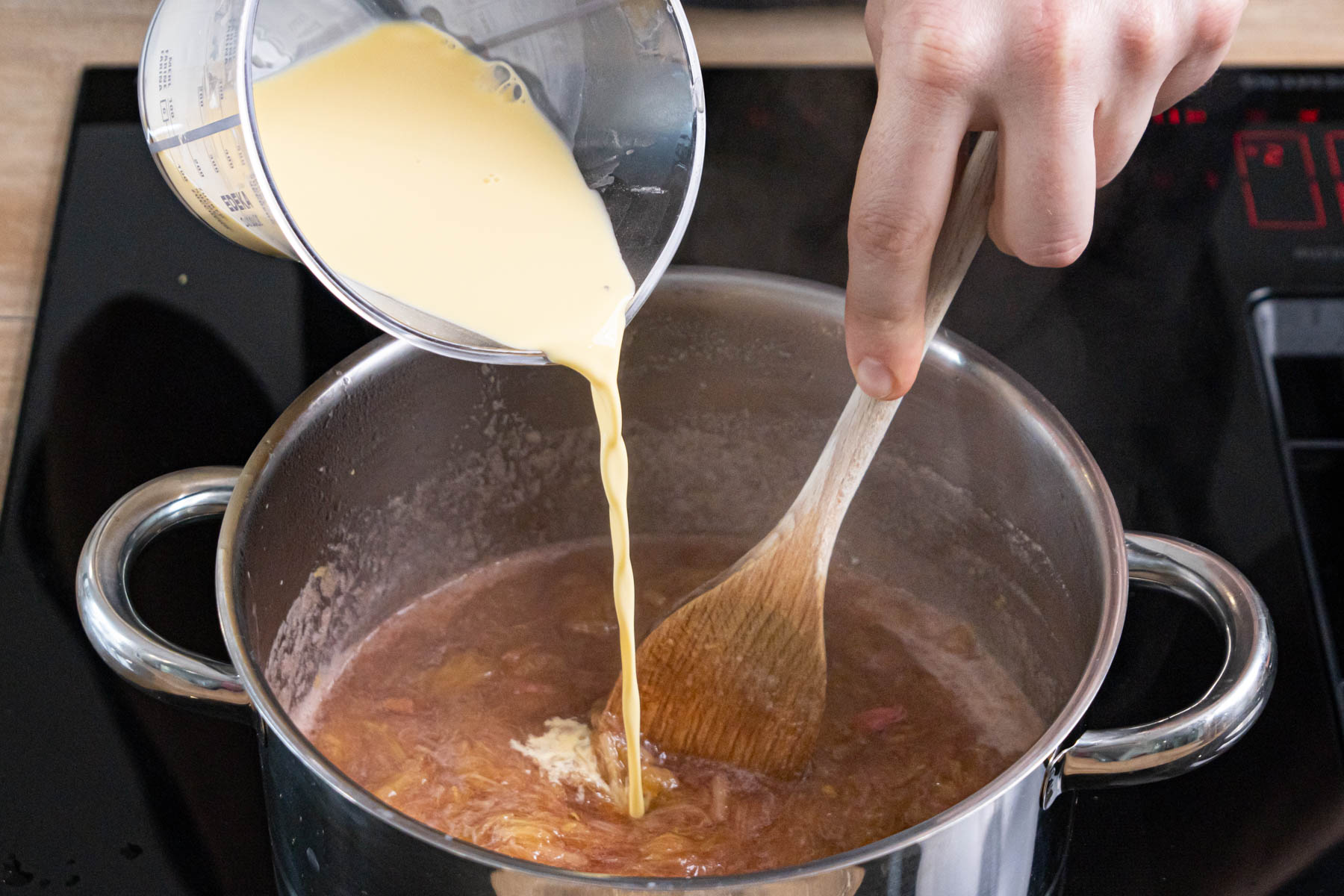 Puddingmasse zum Rhabarber gießen und aufkochen