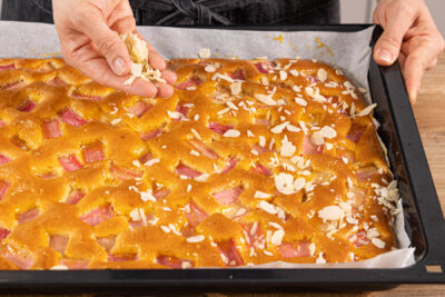 Rhabarberkuchen mit Marmelade bestreichen und mit Mandelblättchen bestreuen