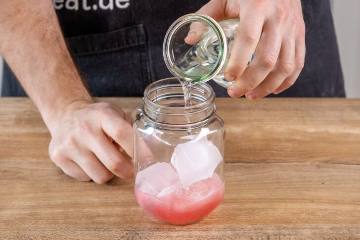 Mineralwasser ins Glas gießen