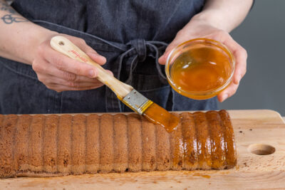 Rehrücken-Kuchen mit Aprikosenmarmelade bestreichen