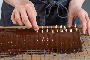 Rehrücken-Kuchen mit Mandelstiften dekorieren