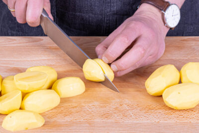 Kartoffeln schälen, halbieren und kochen