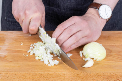 Zwiebeln und Knoblauch schälen und fein würfeln