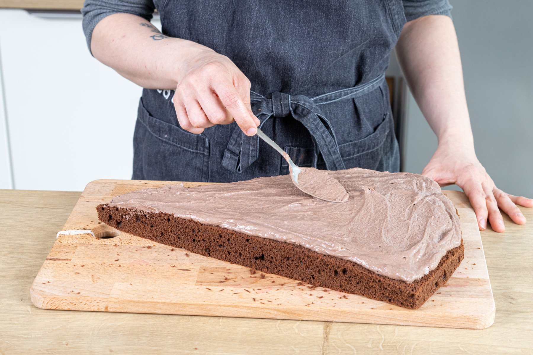 Puddingcreme auf dem unteren Boden der Schultüten-Torte verstreichen