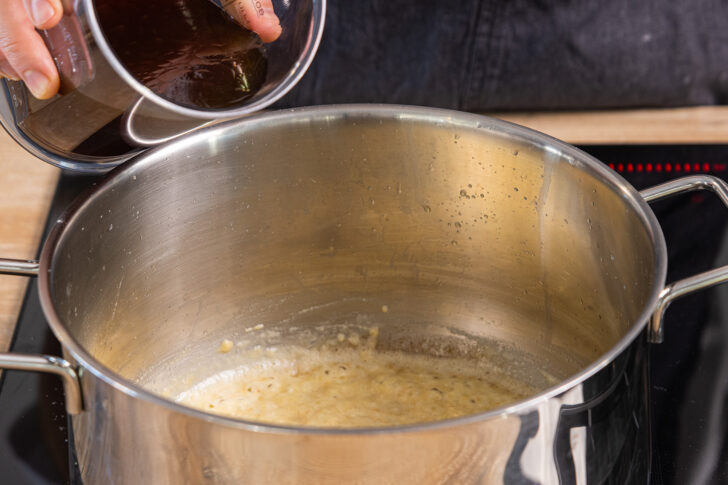 Rinderbrühe in den Topf zur Butter-Mehl-Mischung geben
