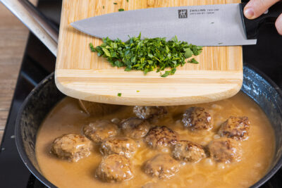 feingehackte Petersilie zur schwedischen Köttbullar geben
