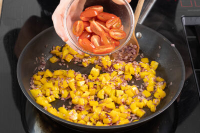 Tomaten und Eiermasse in die Pfanne geben