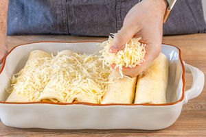 Zarte Hähnchen-Enchiladas mit Käse toppen