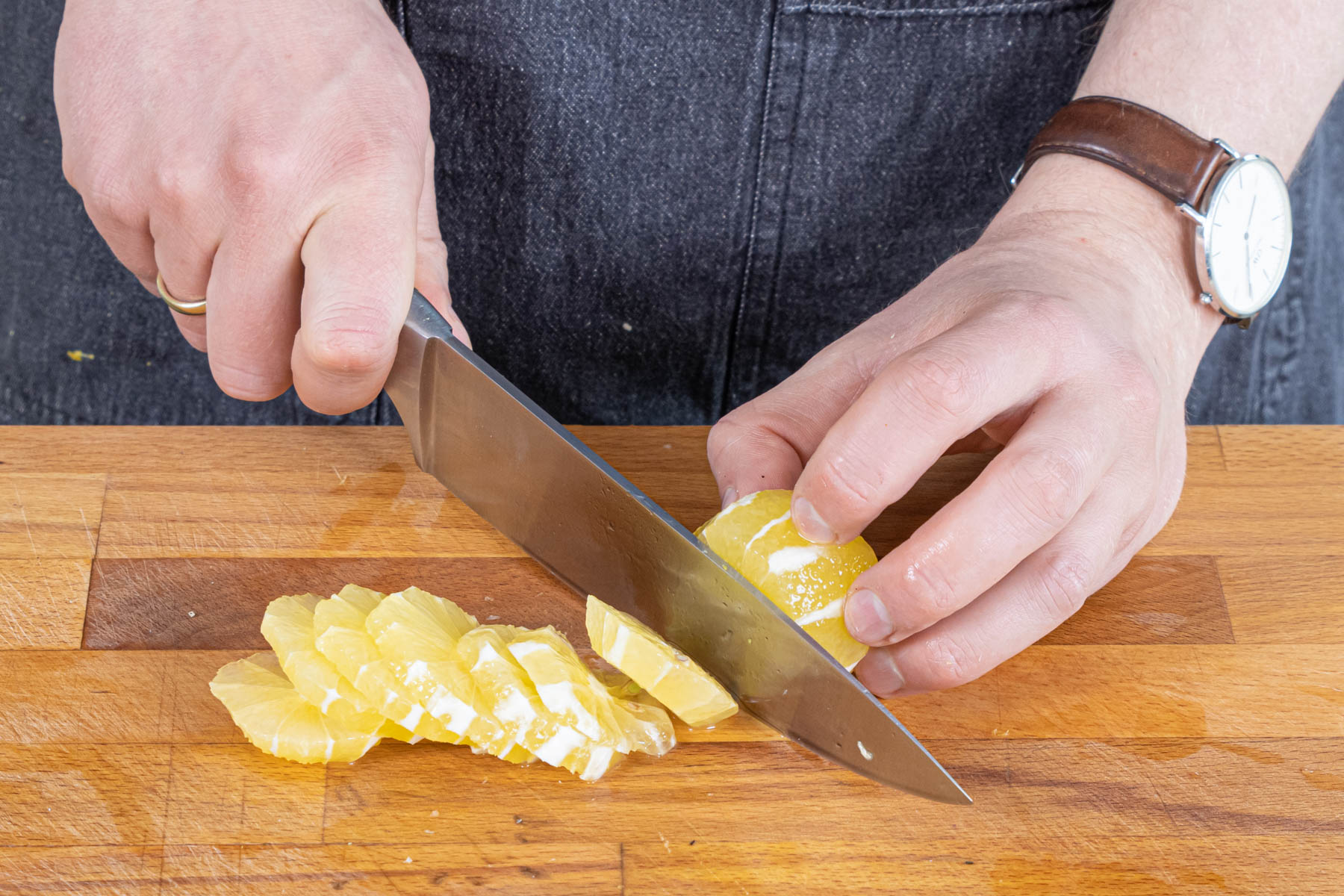 Zitronen schälen und in Scheiben schneiden