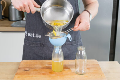 Zitronensirup in Flaschen füllen