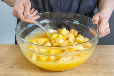 Apfelstücke zu dem Weinpudding geben