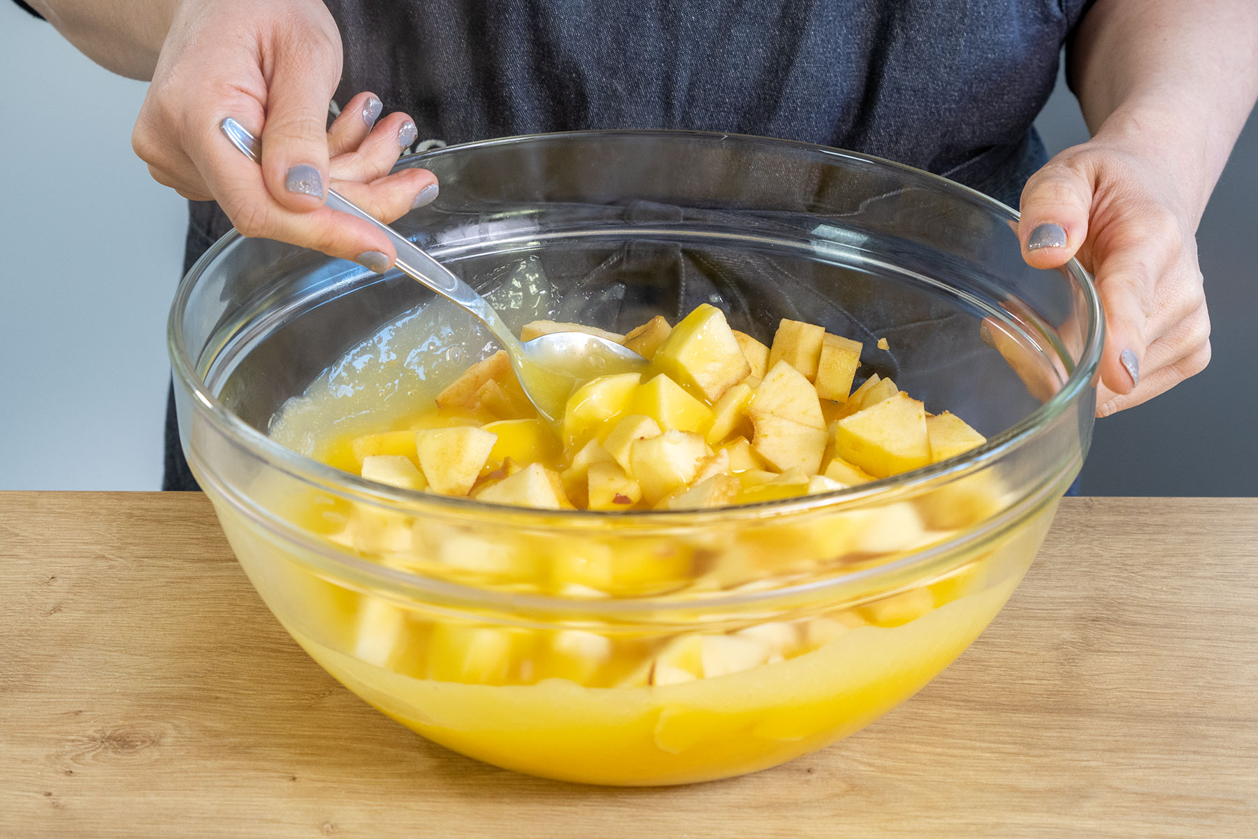 Apfelstücke zu dem Weinpudding geben