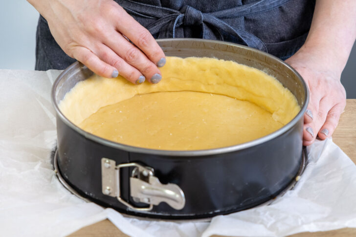 Mürbeteig als Boden für die Apfel-Wein-Torte in die Springform geben