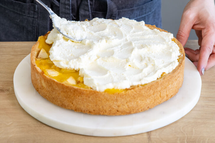 Sahne auf die Apfel-Wein-Torte streichen