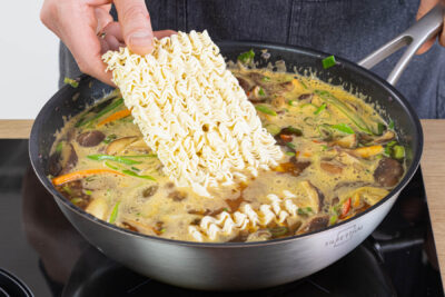 Mie-nudeln in der Suppe köcheln lassen, bis sie weich sind