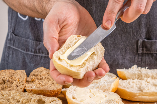 Brötchen mit Butter bestreichen