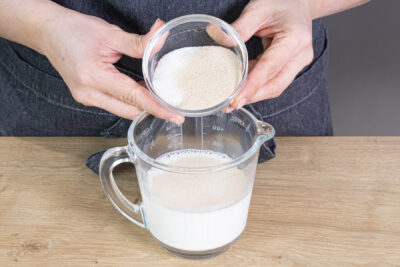 Milch mit Zucker und Trockenhefe mischen