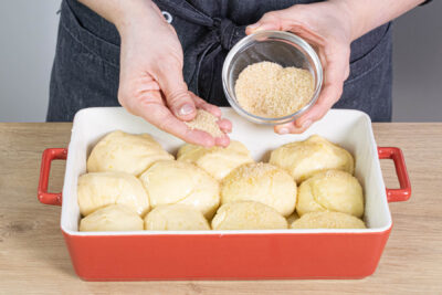 Buchteln mit Butter bestreichen und Rohrzucker darüber streuen