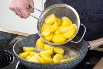 Kartoffeln in die Pfanne geben