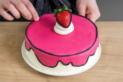 schwarze Fondantstränge an der Comic-Torte anbringen