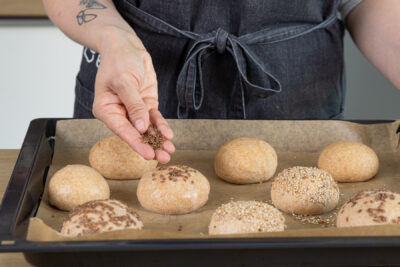 Dinkelvollkornbrötchen mit Leinsamen bestreuen