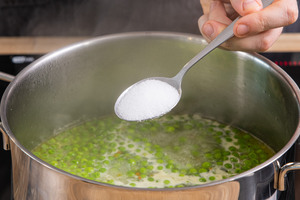 Erbsencremesuppe mit Salz, Pfeffer und Muskat würzen