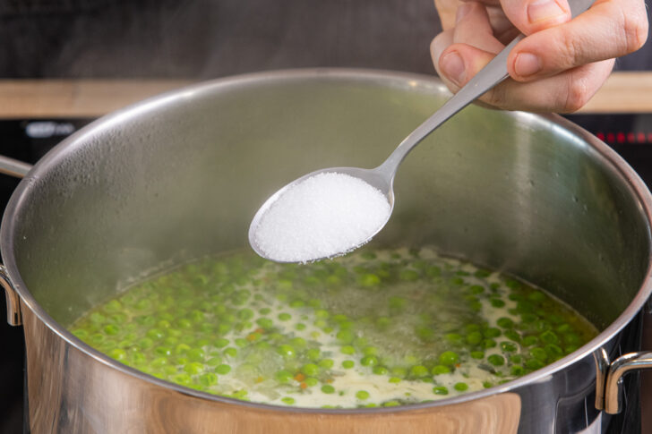Erbsencremesuppe mit Salz, Pfeffer und Muskat würzen