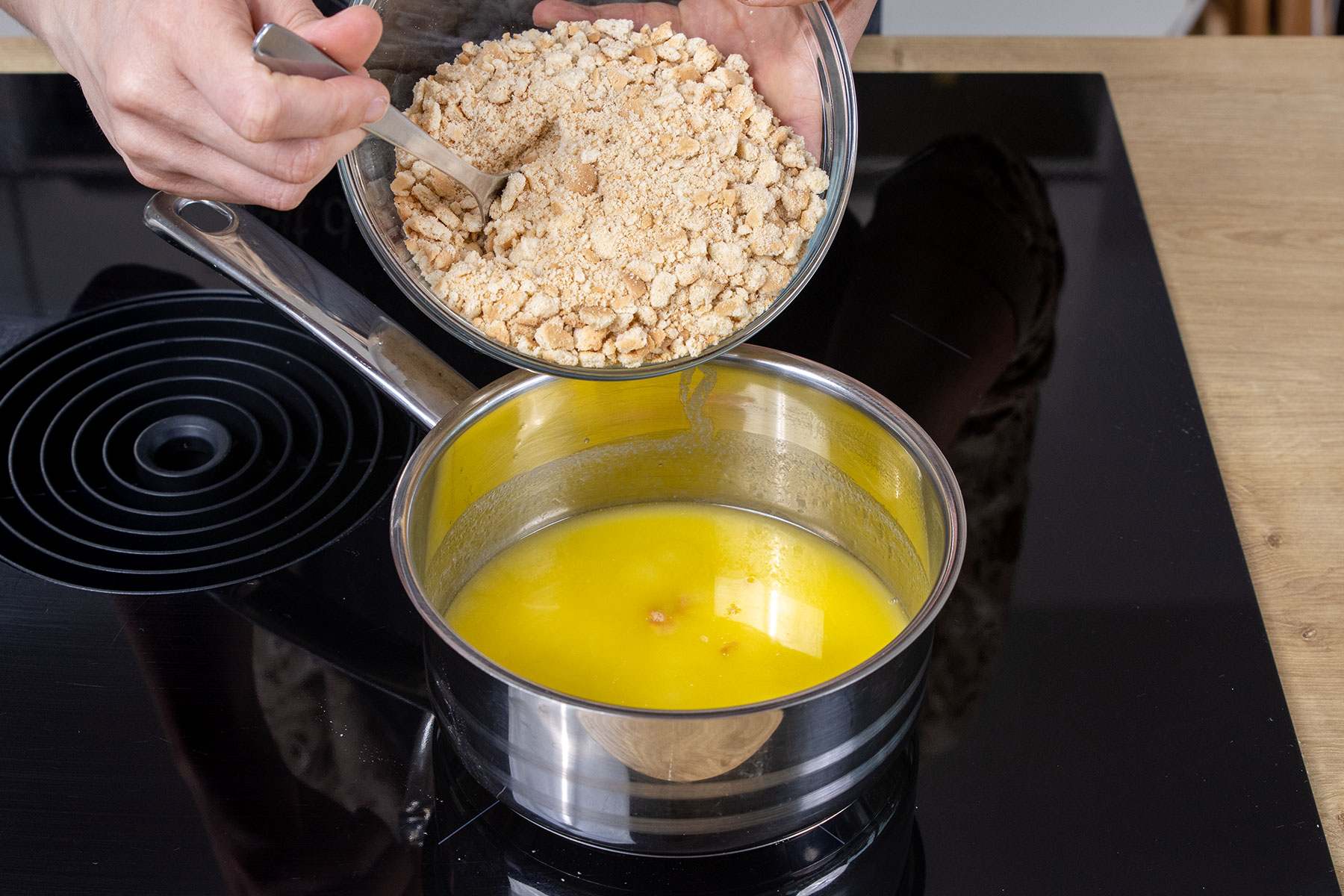 Kekskrümel zur geschmolzenen Butter geben
