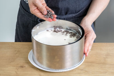 Schokoraspel auf die Erdbeertorte mit Mascarpone streuen