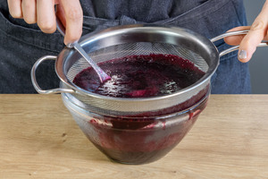 Blaubeerkompott durch ein Sieb geben