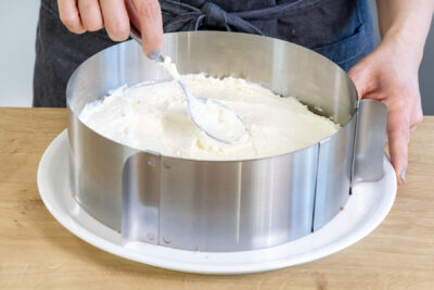 Creme auf den Boden der Blaubeertorte geben