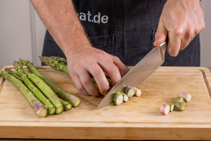 grünen Spargel in grobe Stücke schneiden