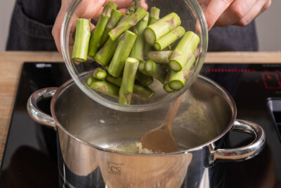 grünen Spargel in Topf geben