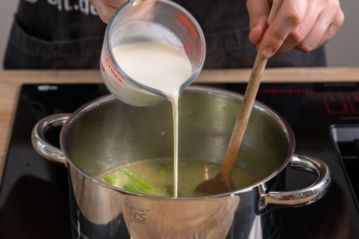 Sahne zur Spargelsuppe gießen